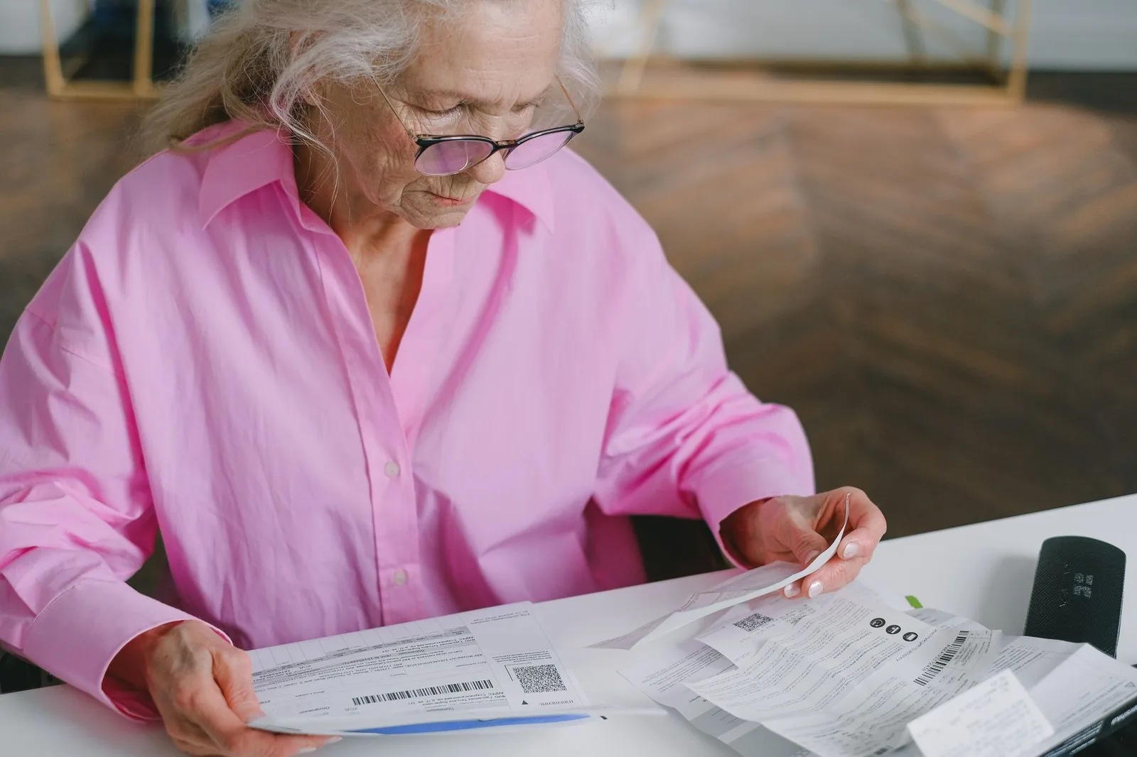Older woman reading paperwork at a table