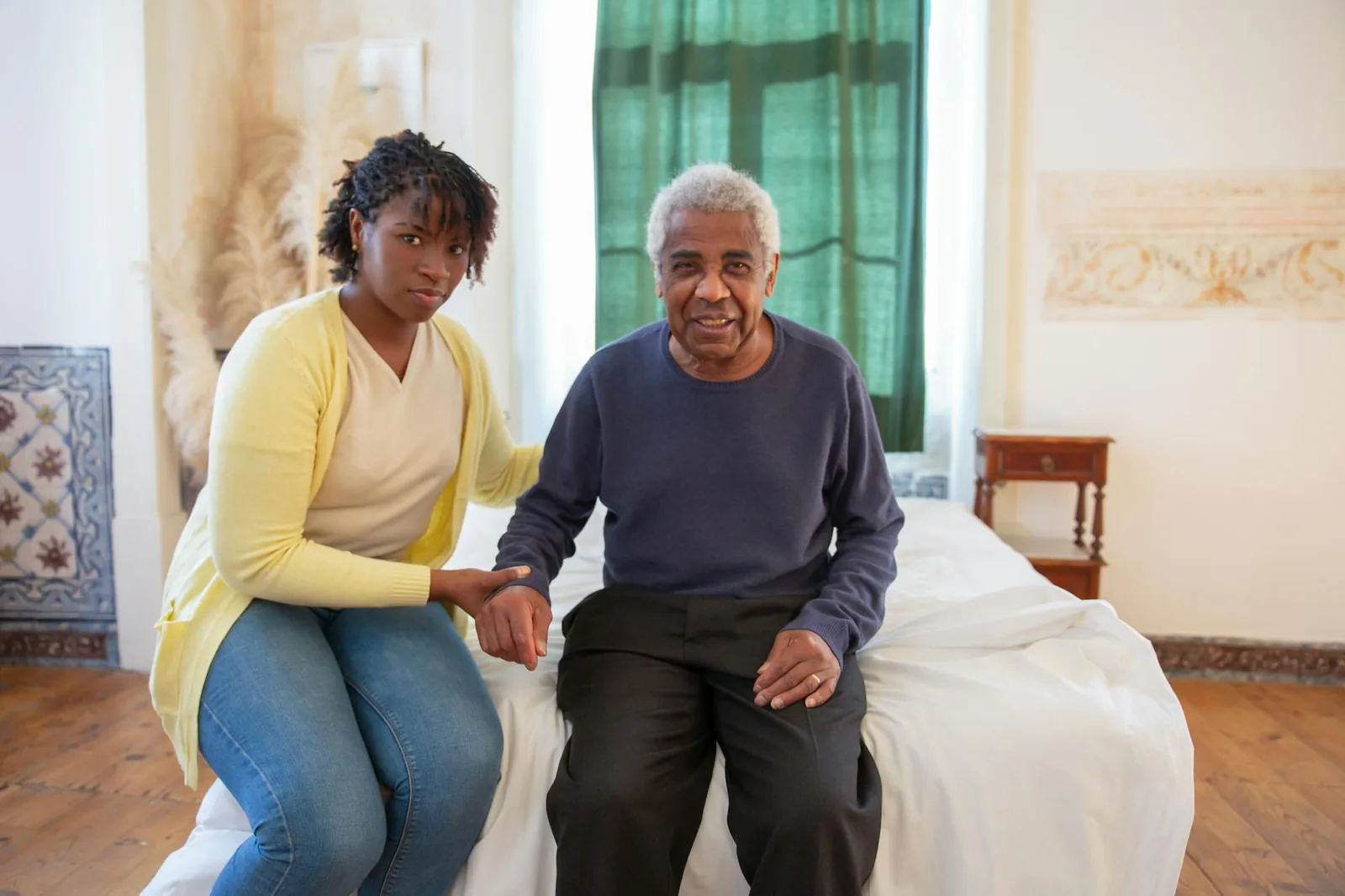 Adult daughter sitting with her elderly father, talking warmly about the path ahead for his care.