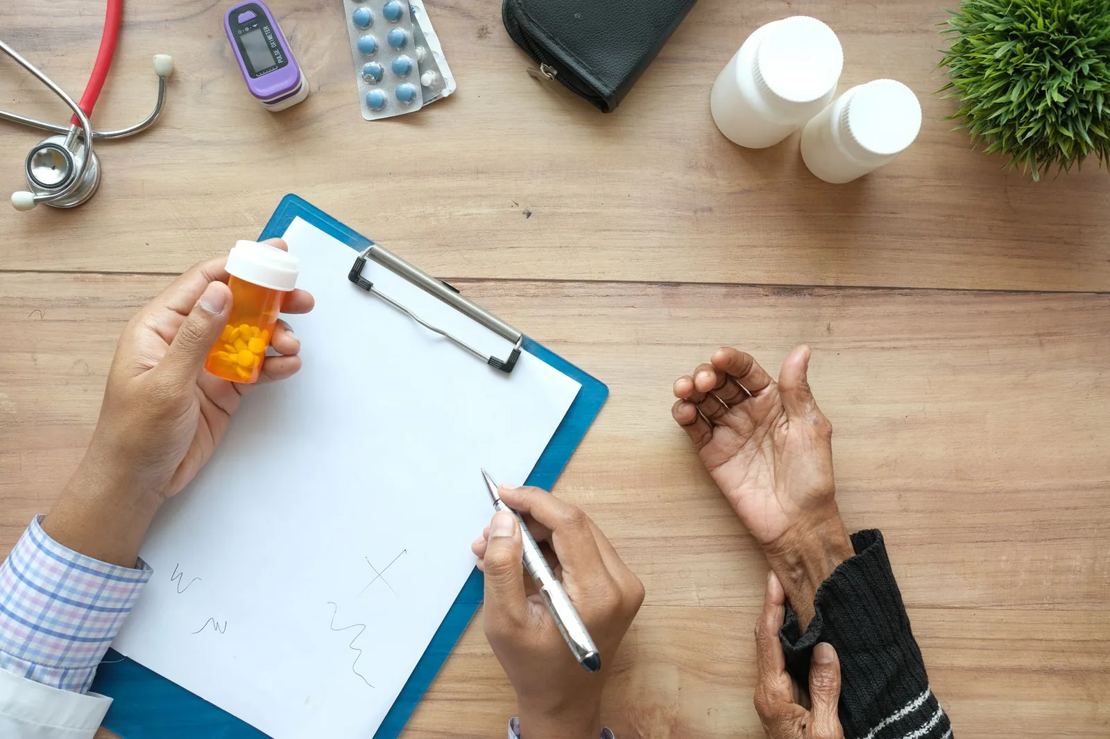 Doctor and older patient at a desk with a pill bottle