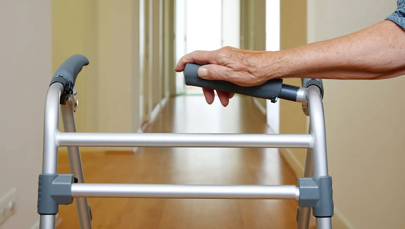 Older adult's hand gripping a folding walker