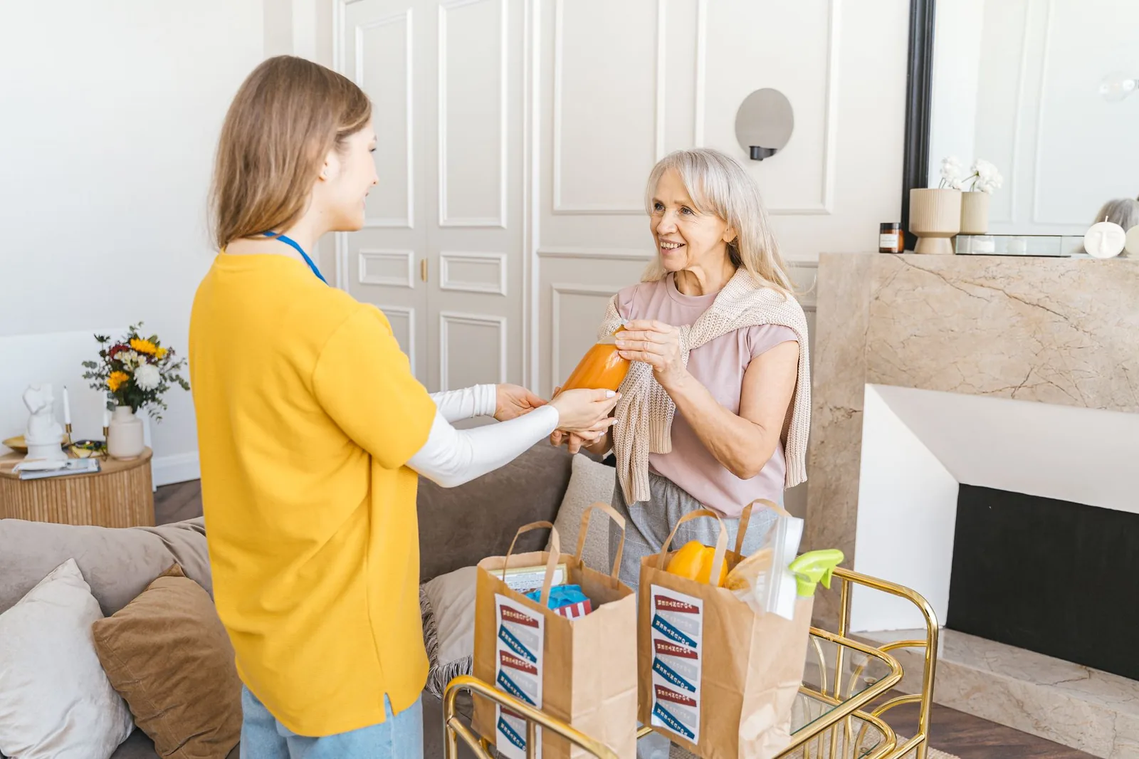 Caregiver handing a juice bottle to an older woman