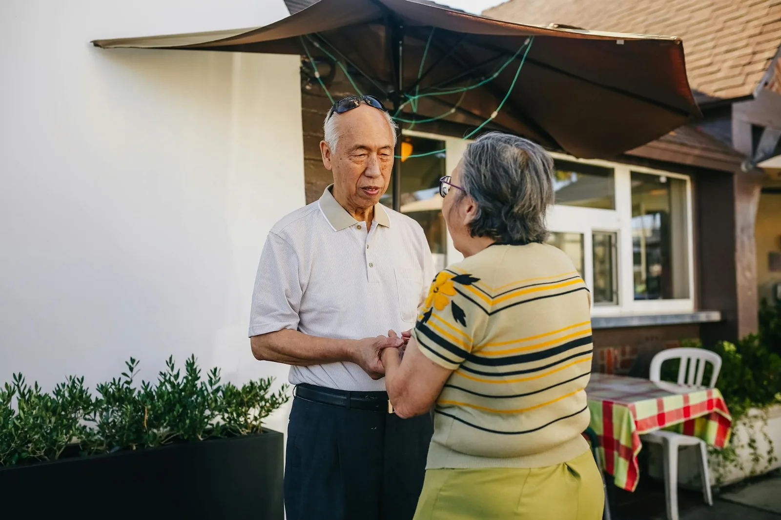 A senior couple holding hands, expressing reassurance and quiet affection.