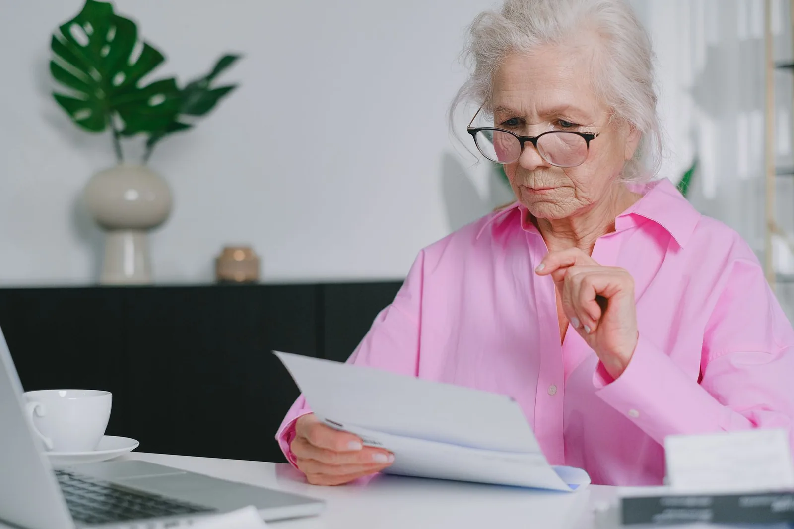 Older woman reading documents at a table